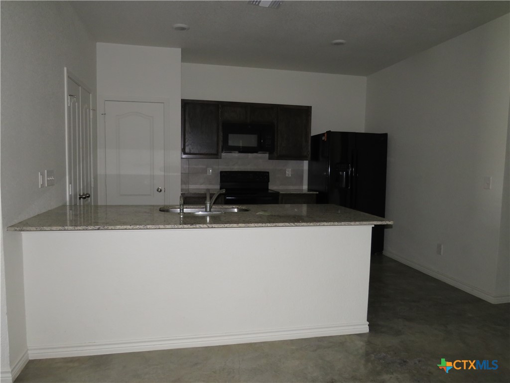 1004 Barbara Jordan Street, Unit B Killeen, TX 76543 - Photo 5 of 13 a living room with stainless steel appliances kitchen island sink and refrigerator