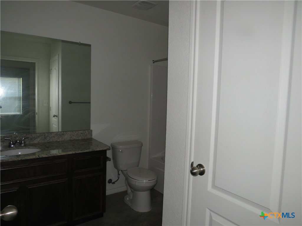 1004 Barbara Jordan Street, Unit B Killeen, TX 76543 - Photo 9 of 13 a bathroom with a granite countertop toilet and sink
