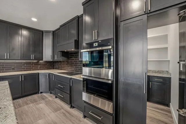 a kitchen with stainless steel appliances granite countertop a refrigerator and a sink