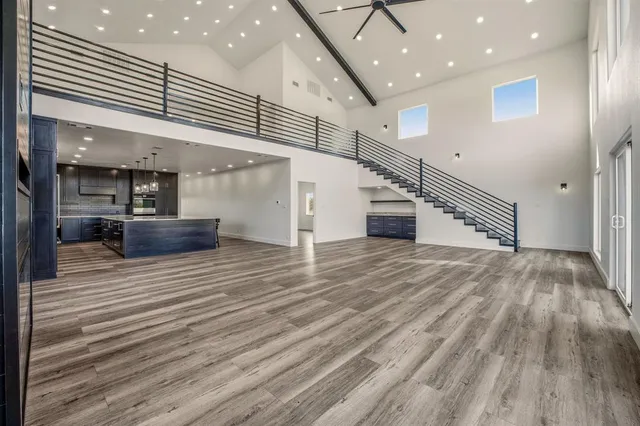 a view of a hallway with stairs and wooden floor