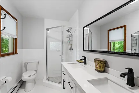 a bathroom with a sink a toilet and a large mirror