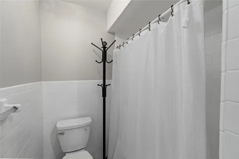 a white toilet sitting next to a shower