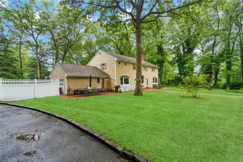 a front view of a house with a yard and trees