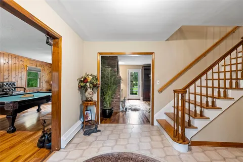 a view of an entryway with wooden floor and a livingroom view