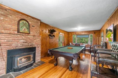 a living room with furniture a fireplace and floor to ceiling window