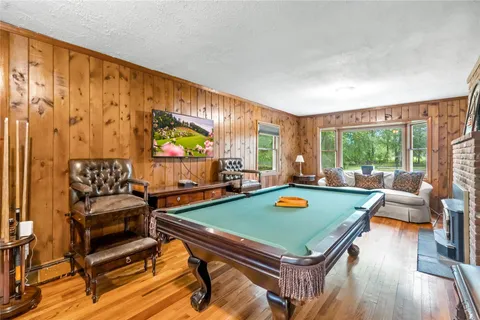 a bed room with furniture pool table and a large window