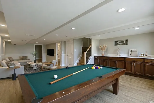 a living room with kitchen pool table and chairs