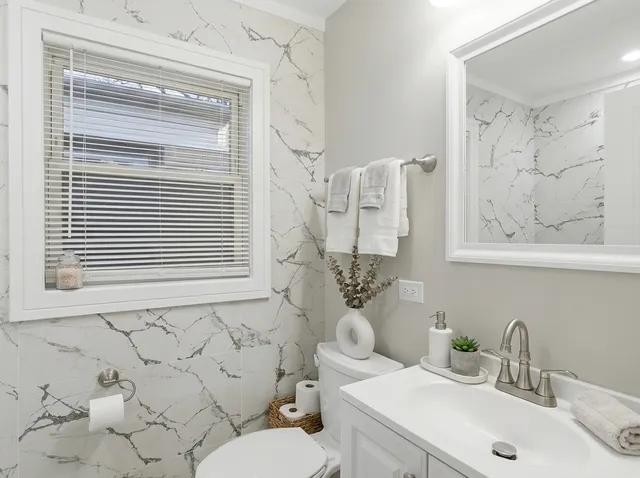 a bathroom with a sink a toilet and a mirror