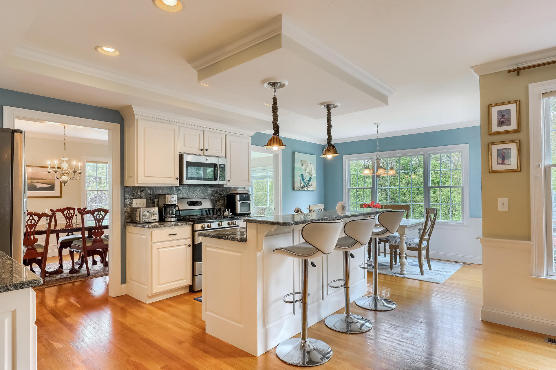 140 Great Marsh Road West Barnstable, MA 02668 - Photo 14 of 46 a kitchen with stainless steel appliances granite countertop a stove top oven a sink a dining table and chairs with wooden floor