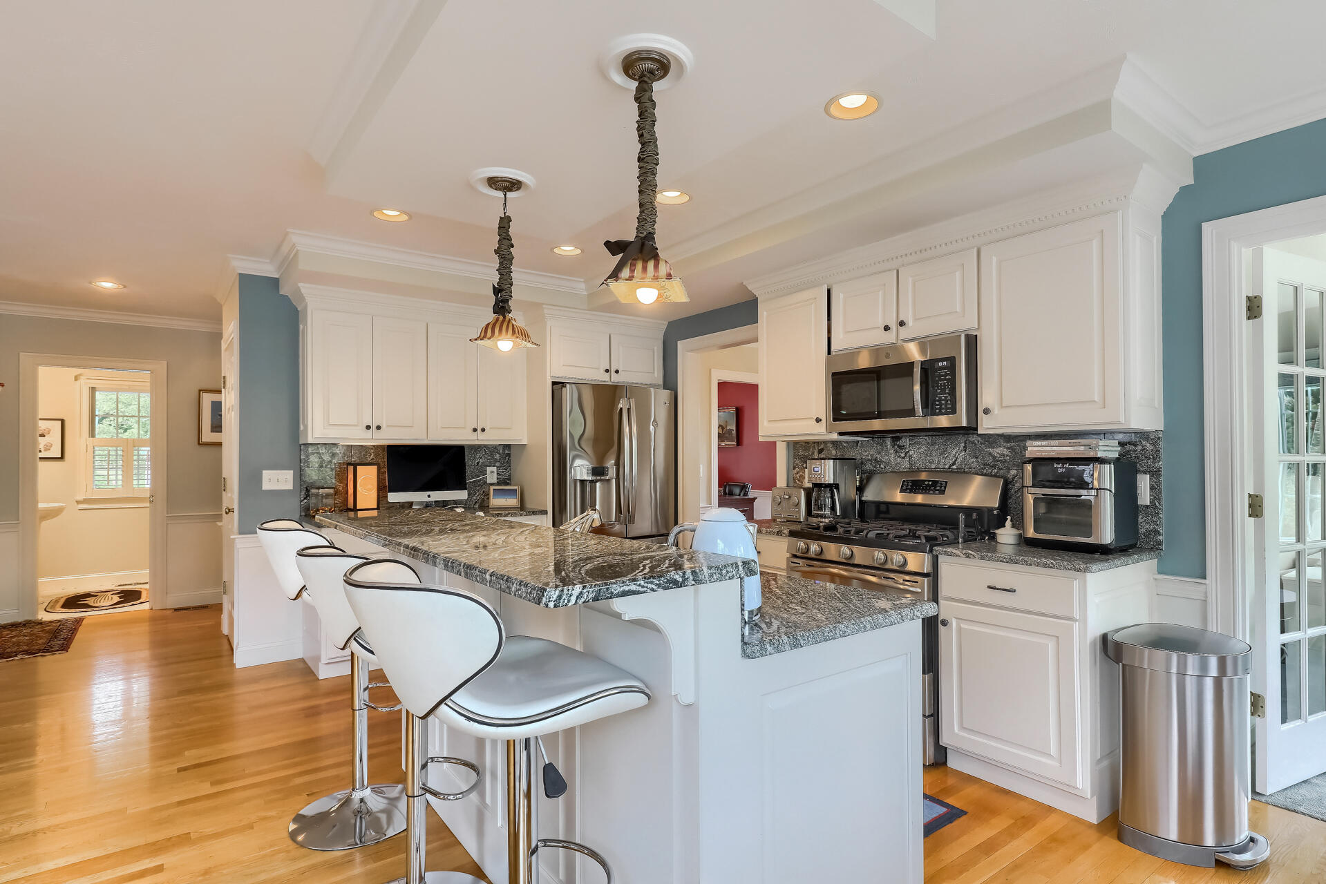 140 Great Marsh Road West Barnstable, MA 02668 - Photo 10 of 46 a kitchen with stainless steel appliances kitchen island granite countertop a stove a sink a refrigerator a microwave oven with white cabinets and wooden floor