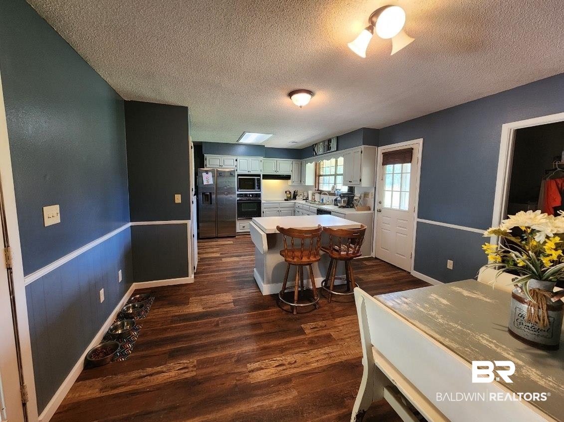 640 Horseshoe Road Brewton, AL 36426 - Photo 11 of 22 Dining space with a textured ceiling and dark hardwood / wood-style floors