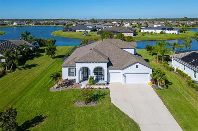 a view of a house with a yard and lake view