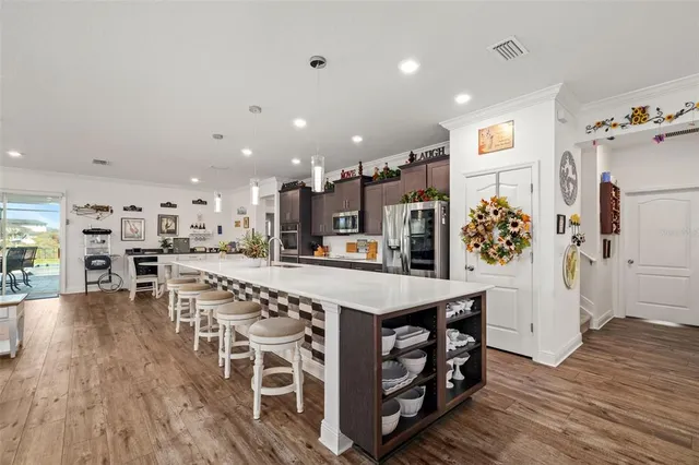 a kitchen with a dining table chairs and wooden floor