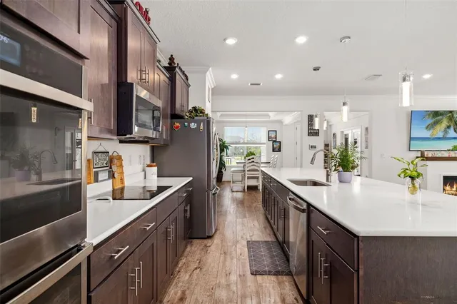 a kitchen with stainless steel appliances a sink a stove top oven a counter space and cabinets