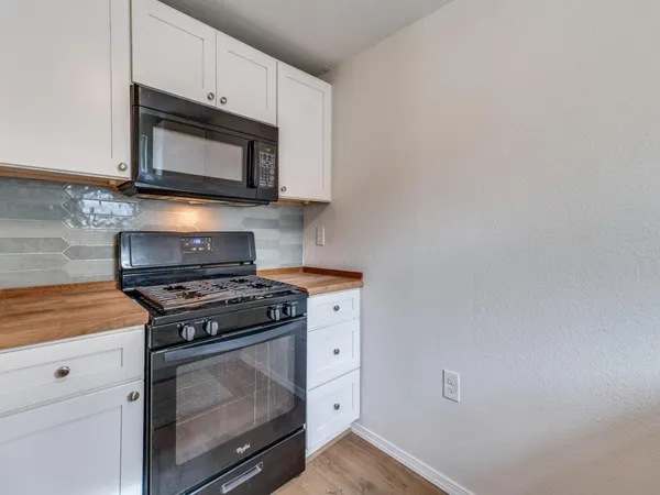 a kitchen with stainless steel appliances a stove microwave and cabinets