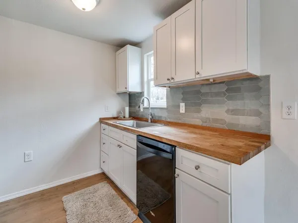 a kitchen with granite countertop white cabinets and white appliances