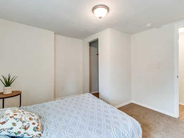 a bedroom with a bed and a potted plant
