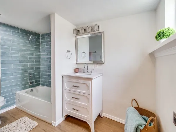 a bathroom with a sink mirror and a bathtub