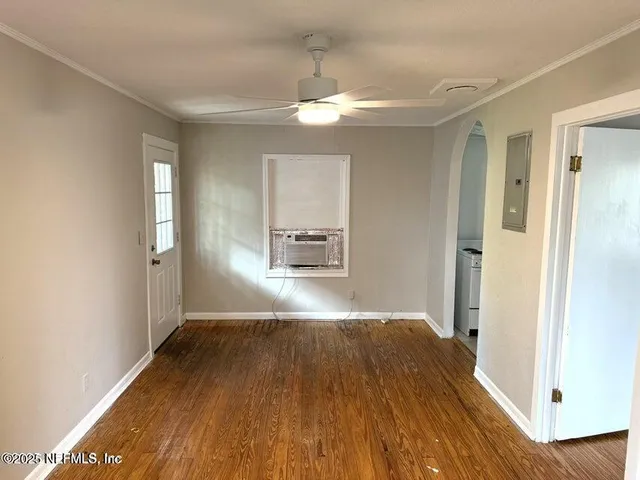 a view of empty room with wooden floor