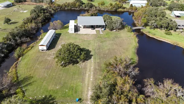an aerial view of residential house with outdoor space and trees