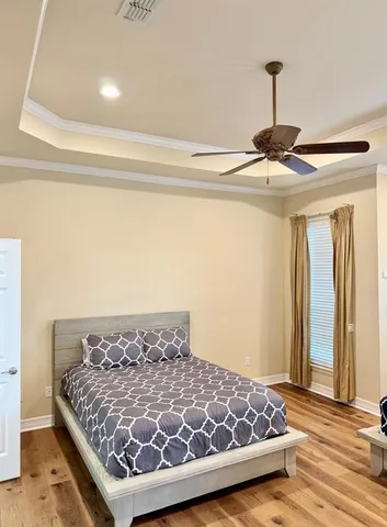 a bedroom with a bed and wooden floor