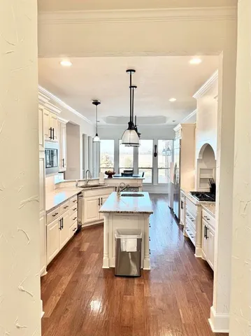 a large kitchen with white cabinets and stainless steel appliances
