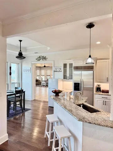 a open kitchen with granite countertop a stove and white cabinets