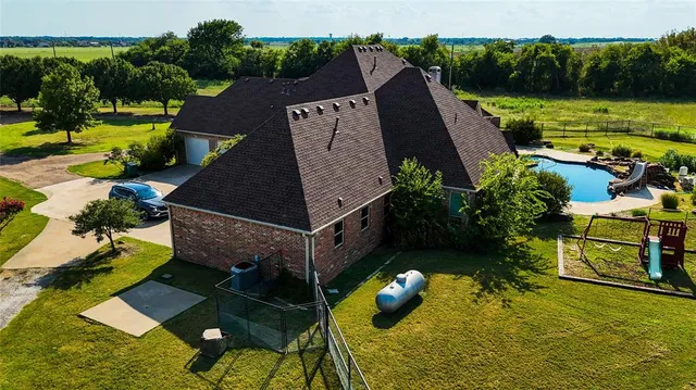 an aerial view of a house with a garden swimming pool and outdoor seating