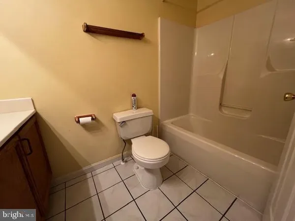 a white toilet sitting next to a bath tub