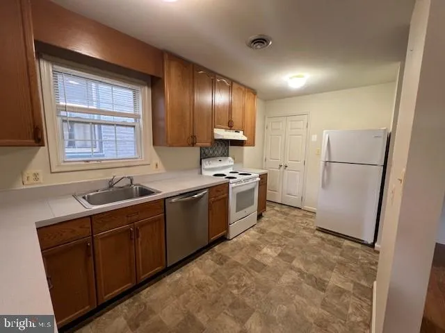 a kitchen with a refrigerator sink stove and cabinets