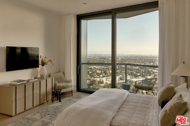 a bedroom with a bed and large window
