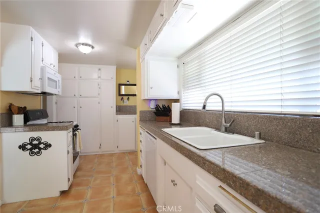 a kitchen with a sink a stove a refrigerator and a window