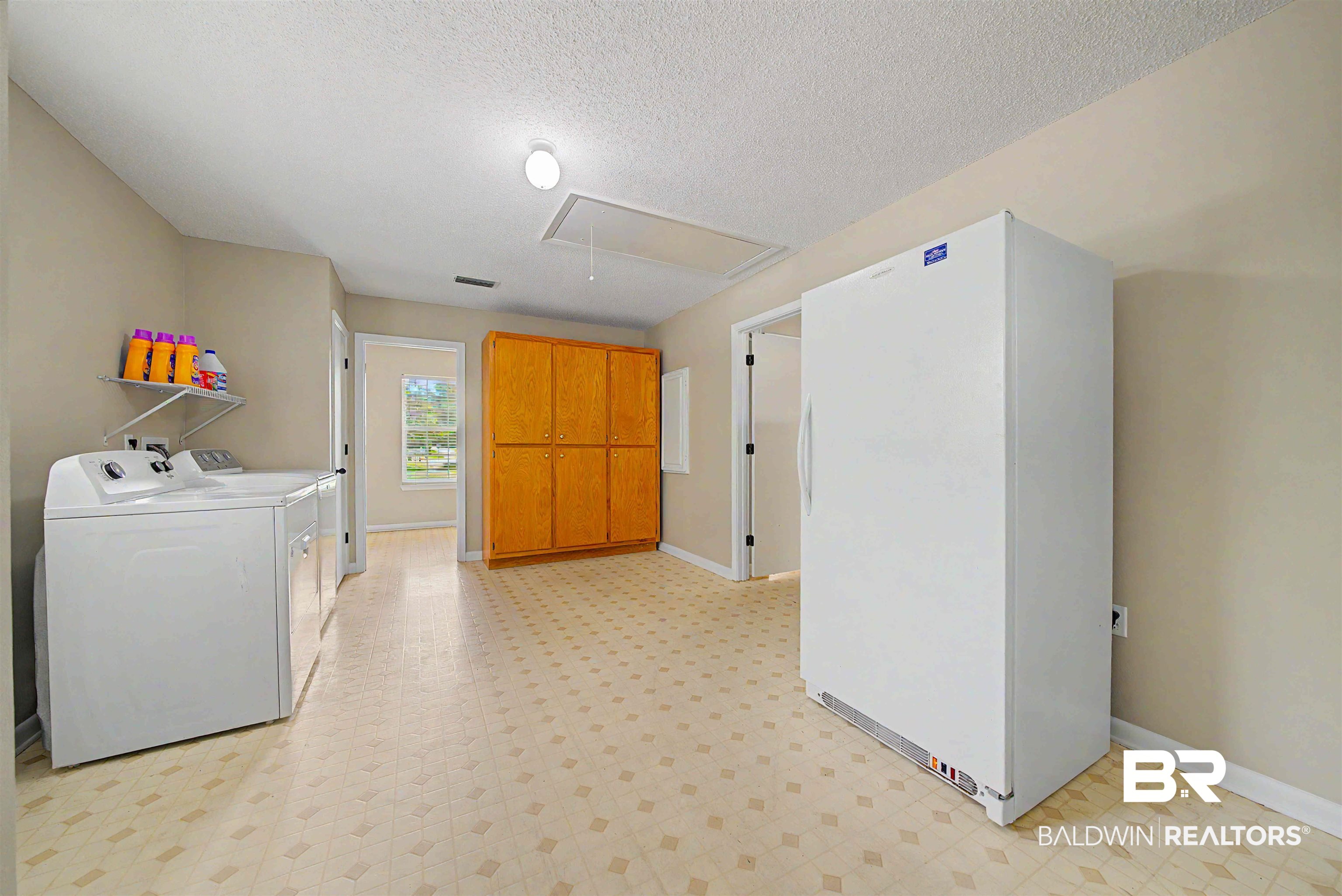 22963 Highway 98 Foley, AL 36535 - Photo 33 of 52 Spacious utility area featuring patterned flooring, built-in cabinetry, and neutral wall tones