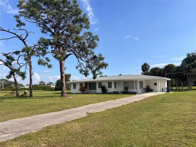 a view of swimming pool with outdoor seating and house in the background