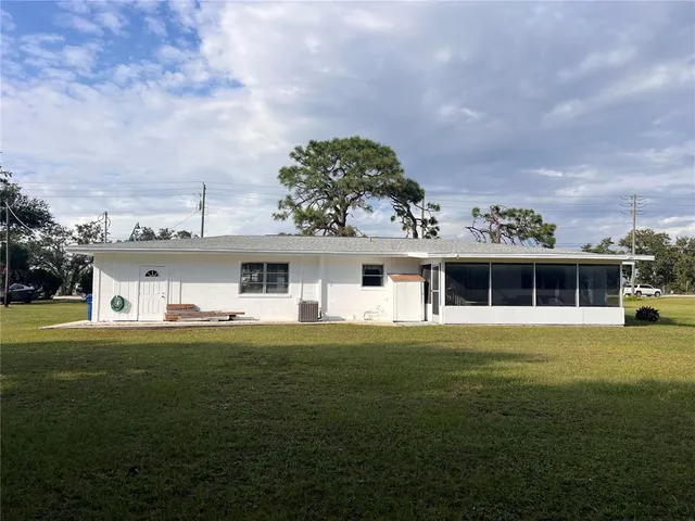 a front view of a house with a garden and trees