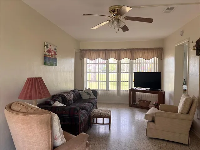 a living room with furniture ceiling fan and a flat screen tv