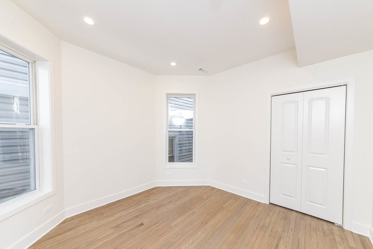 2825 North Rockwell Street, Unit 2 Chicago, IL 60618 - Photo 11 of 22 an empty room with wooden floor and windows