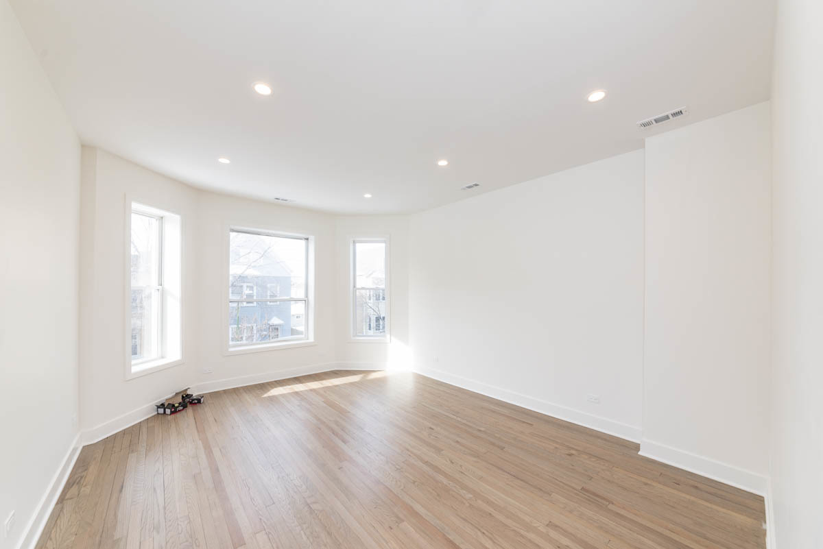 2825 North Rockwell Street, Unit 2 Chicago, IL 60618 - Photo 2 of 22 an empty room with wooden floor and windows