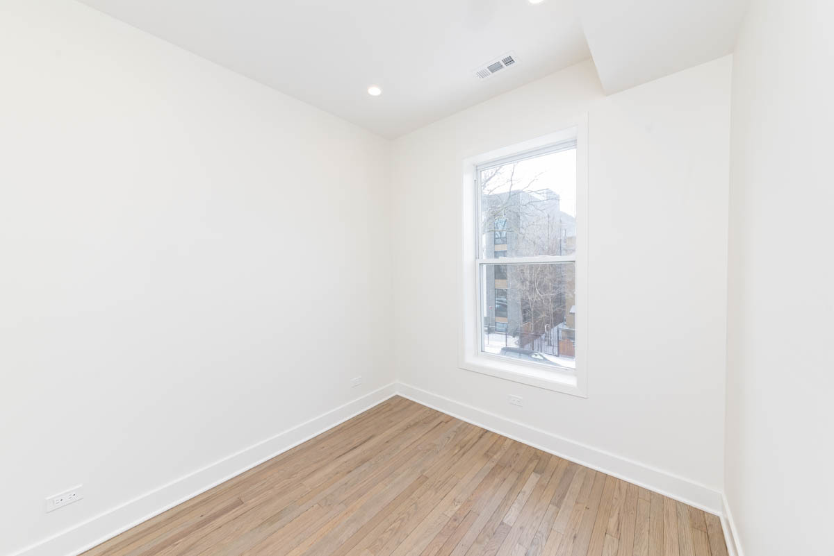2825 North Rockwell Street, Unit 2 Chicago, IL 60618 - Photo 6 of 22 a view of an empty room with wooden floor and a window