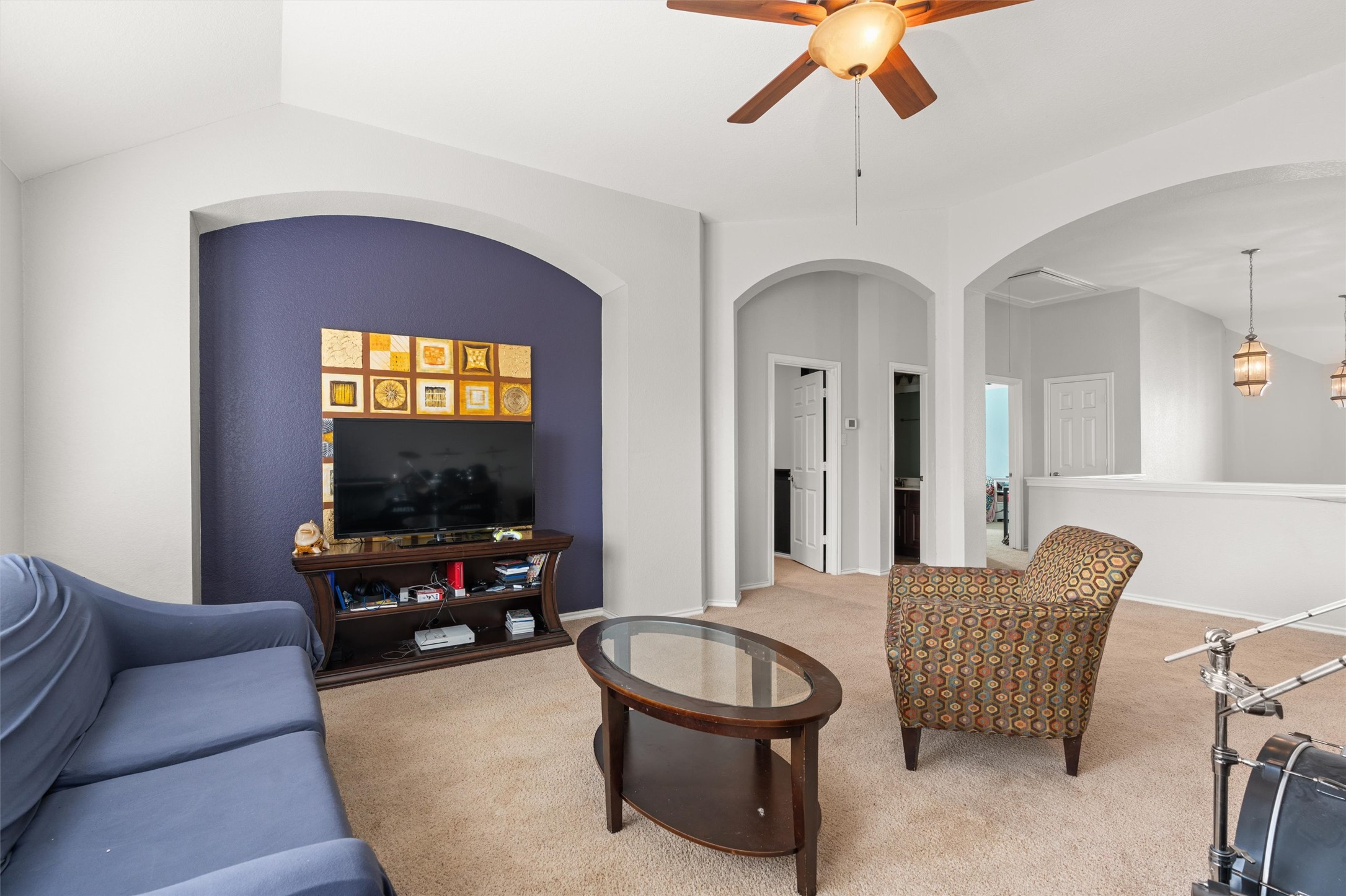 400 Red Hawk Drive Leander, TX 78641 - Photo 17 of 32 Living room featuring a ceiling fan, light carpet, and arched walkways