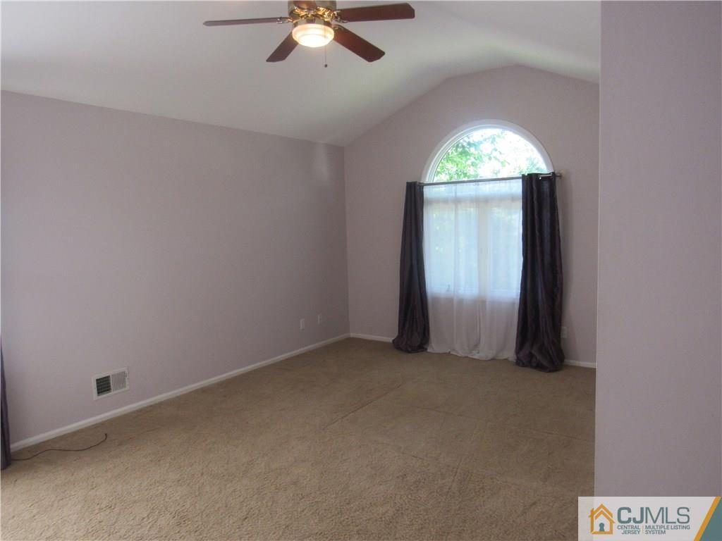 3 Hillsdale Road Edison, NJ 08820 - Photo 14 of 27 an empty room with a chandelier fan and windows