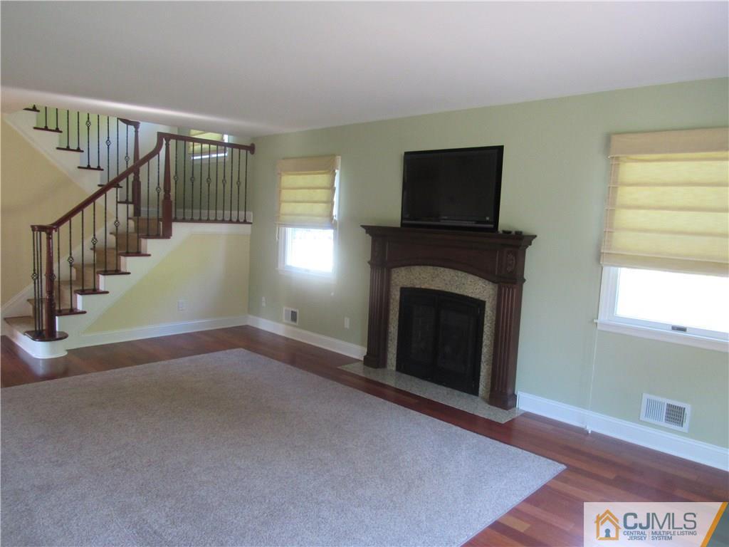 3 Hillsdale Road Edison, NJ 08820 - Photo 5 of 27 a view of an empty room with wooden floor fireplace and a window