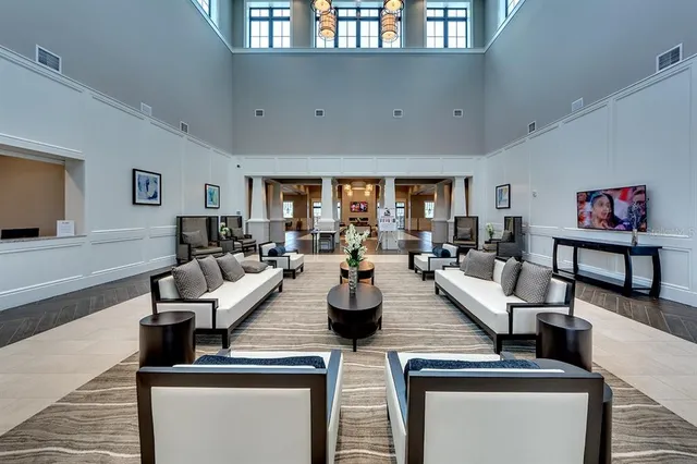 a room with furniture a flat screen tv and kitchen view