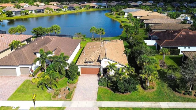 an aerial view of a house with a garden and lake view