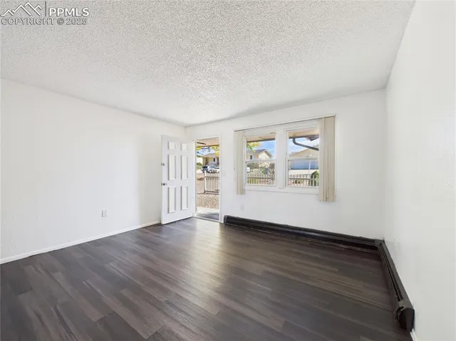 an empty room with wooden floor and window