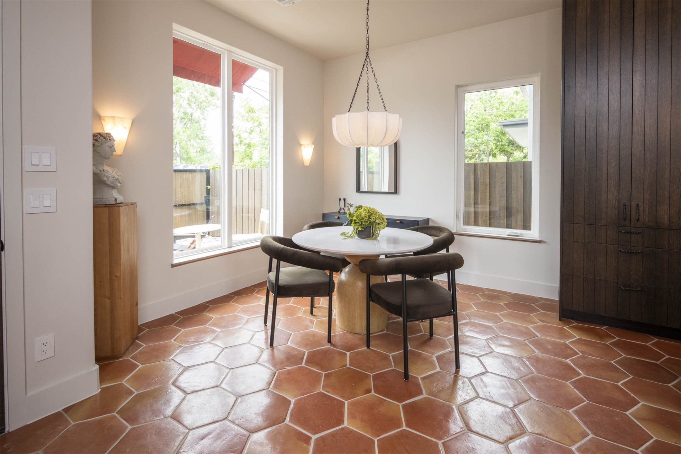 4713 Bolm Road Austin, TX 78702 - Photo 7 of 40 Hexagonal terracotta tile flooring throughout, complemented by a large picture window, a built-in dark wood cabinetry unit, and a contemporary pendant light fixture