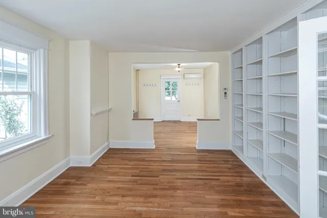 a view of empty room with wooden floor and cabinet