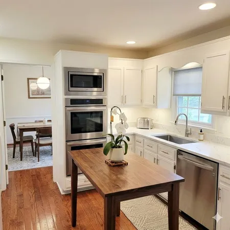 a kitchen with a sink cabinets and wooden floor