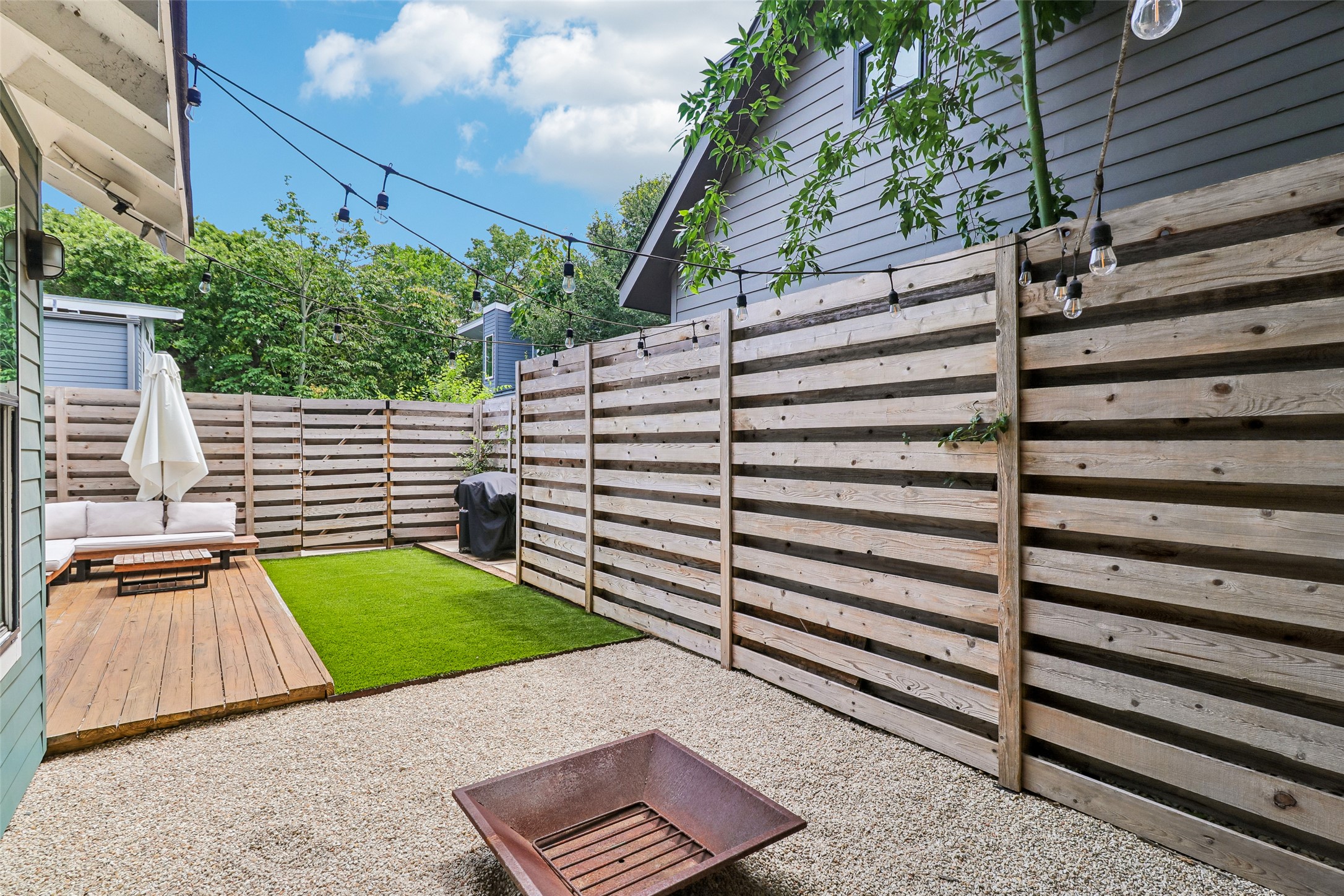 1706 Perez Street, Unit 1 Austin, TX 78721 - Photo 36 of 36 A tranquil backyard haven featuring a spacious deck and inviting fire pit, perfect for outdoor enjoyment.