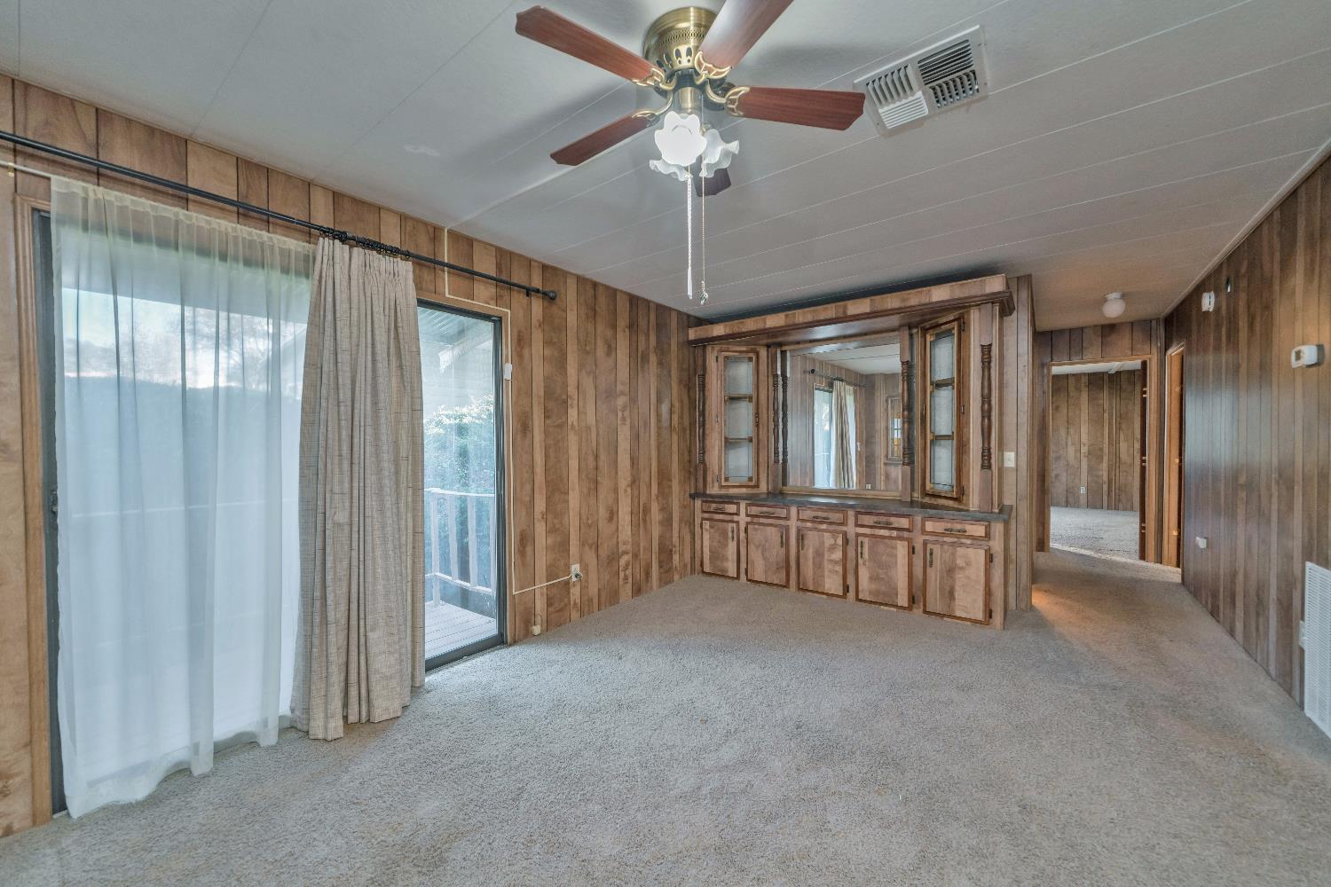 4420 Pleasant Valley Road, Unit 116 Diamond Springs, CA 95619 - Photo 13 of 28 an empty room with chandelier fan and windows